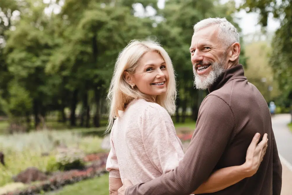 Clinton Township couple smiling with their dental implants