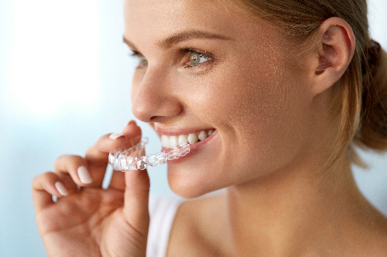 young woman placing her Invisalign clear aligners