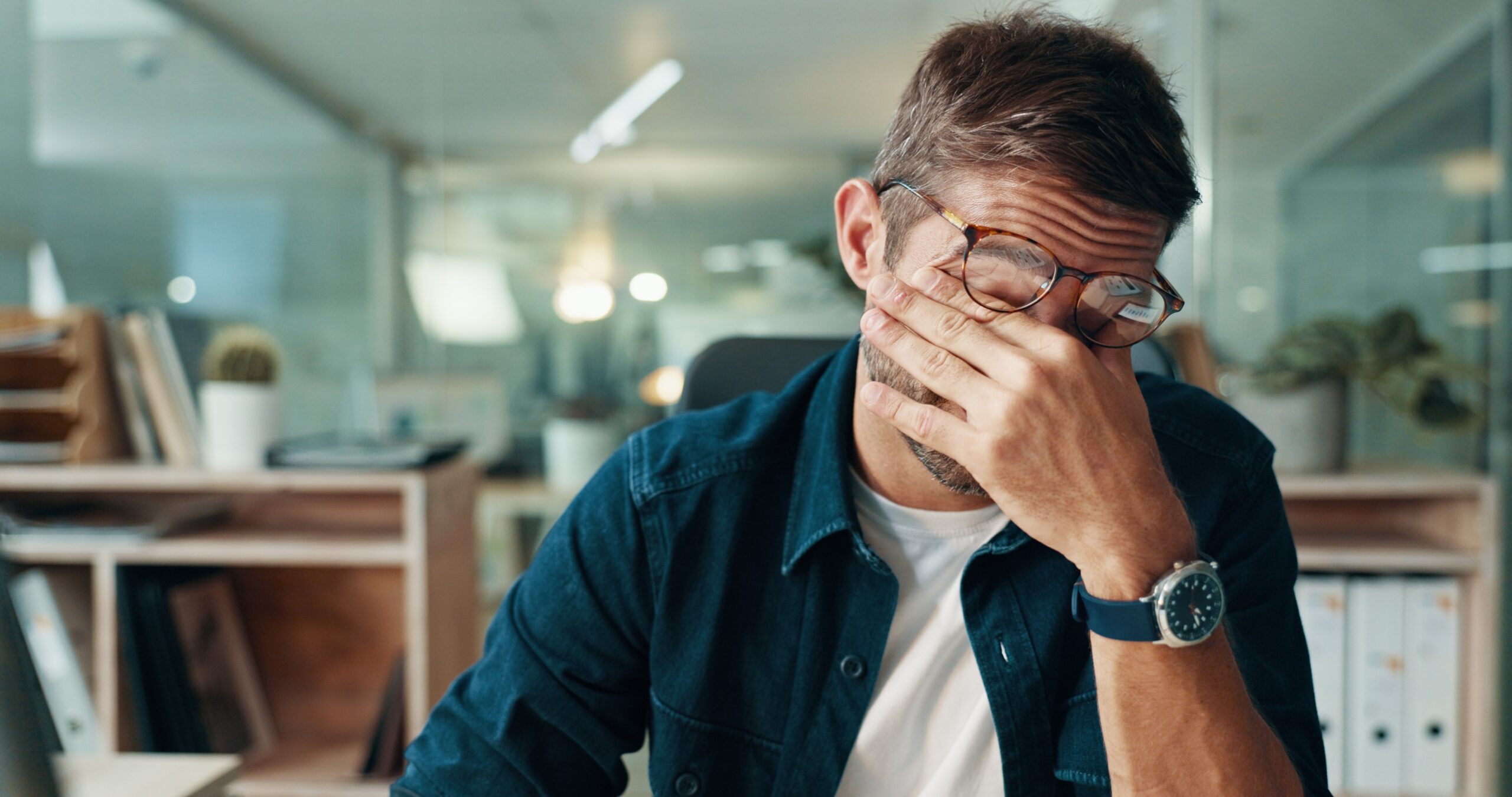 man with a hand over his face suffering from a headache, TMJ disorder