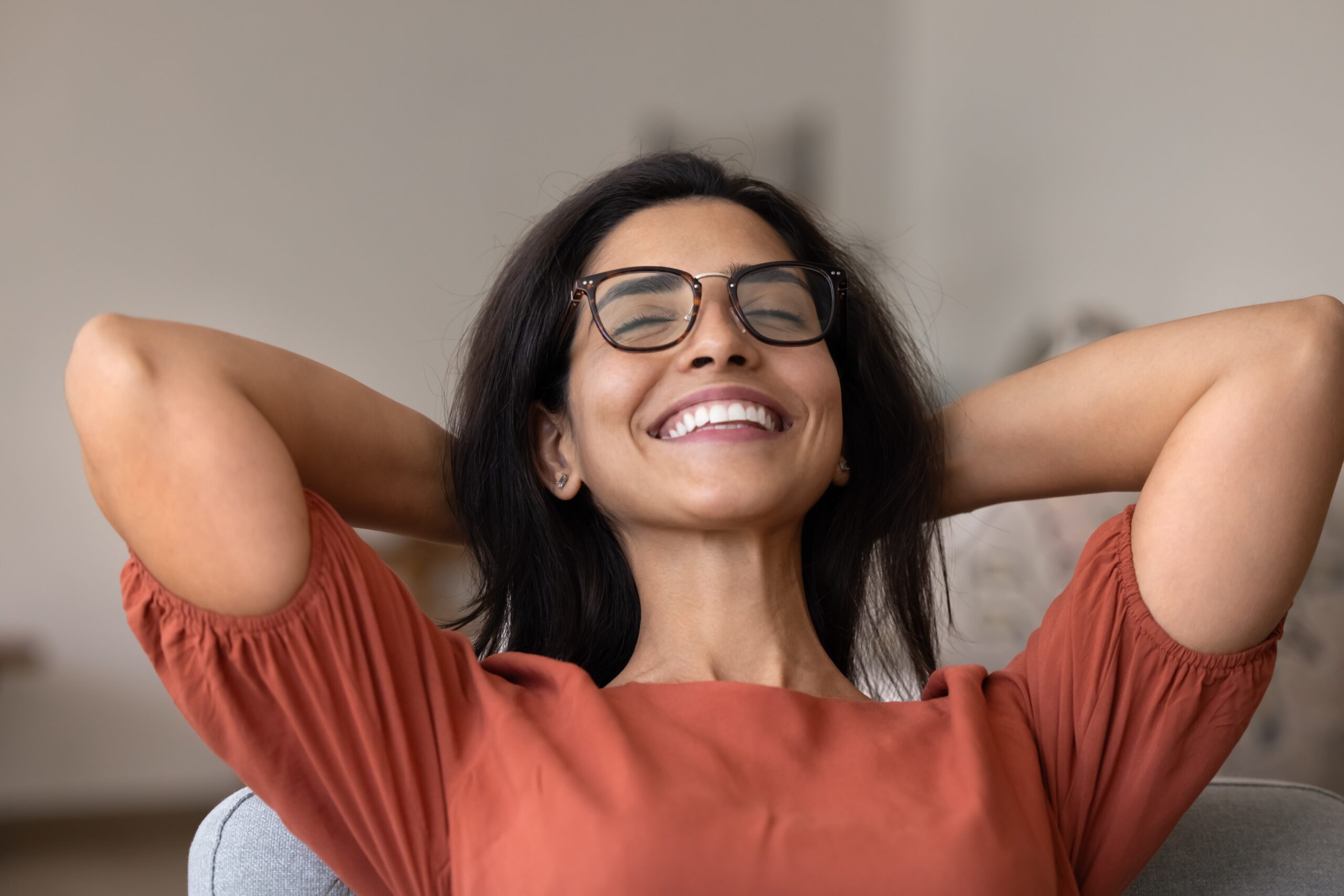 happy young woman, perfect smile, hands behind head