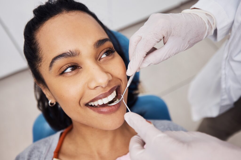 hands of a dentist working on a young woman's smile